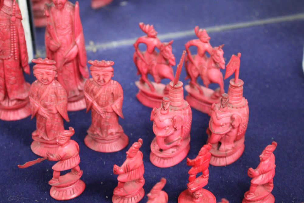 An early 20th century Chinese carved and red stained ivory chess set, carved as opposing Chinese armies, king 12cm